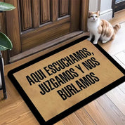 Alfombra de entrada con frase Aquí escuchamos, juzgamos y nos burlamos