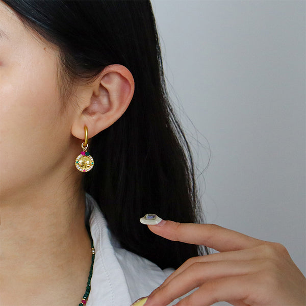 Aretes dorados con diseño de rostro