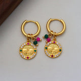 Aretes dorados con diseño de rostro