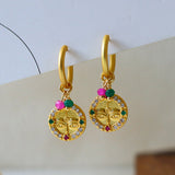 Aretes dorados con diseño de rostro